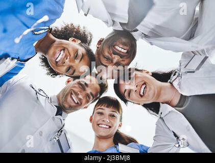 The professional faces of healthcare. Low angle portrait of a diverse team of doctors huddled together in a hospital. Stock Photo