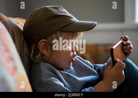 Boy in baseball cap using smart phone Stock Photo