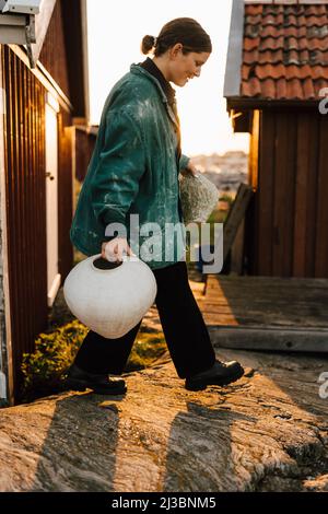 Young woman carrying handmade vases Stock Photo