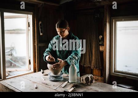 Female potter making vase in workshop Stock Photo