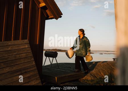 Young woman carrying handmade vases at coast Stock Photo
