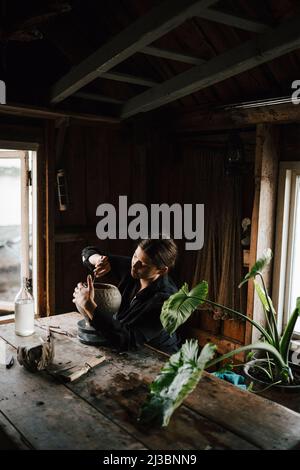 Female potter making vase in workshop Stock Photo