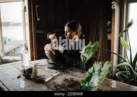 Female potter making vase in workshop Stock Photo