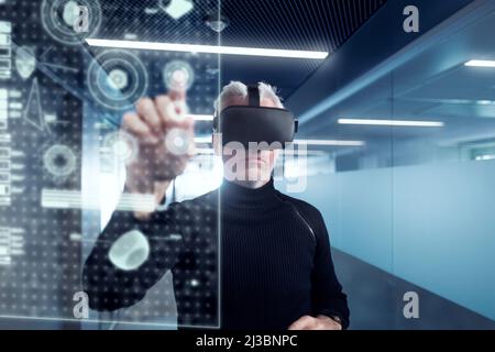 Senior man in virtual reality headset using advanced technology Stock Photo