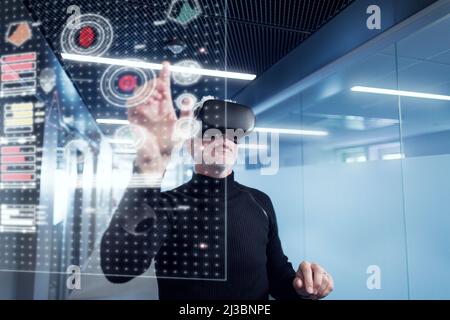 Senior man in virtual reality headset using advanced technology Stock Photo
