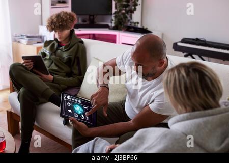 Family relaxing in living room and using tablets Stock Photo