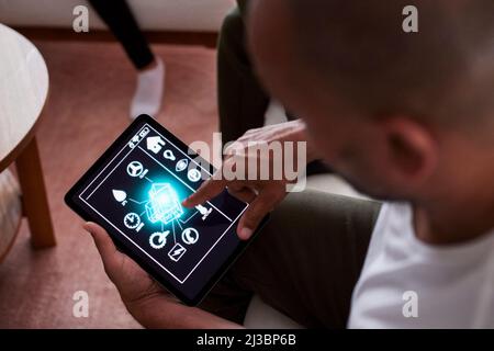 Man using smart home application on tablet Stock Photo