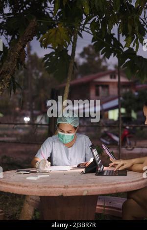 Nurse in protective clothing filling paperwork Stock Photo