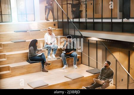 Business people sitting on stairs in office and working Stock Photo