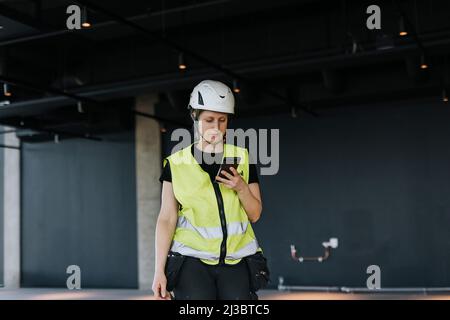 Worker at construction site using cell phone Stock Photo