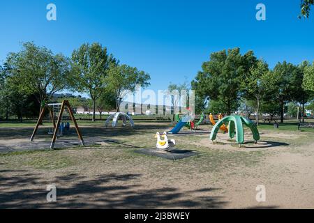 Plasencia, Spain - April 17, 2021: Children's playground in the park. Colorful plastic slide in the park Stock Photo