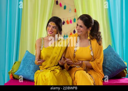 Mother and daughter showing their palms paint with mehndi Stock Photo