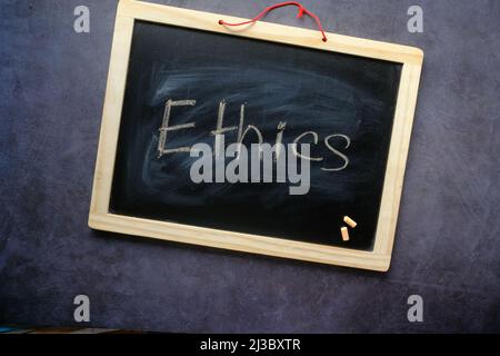 Ethics word on a chalk board on black background , Stock Photo