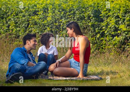 Happy couple with their son spending time in park Stock Photo