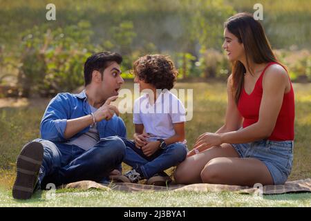 Happy couple with their son spending time in the park Stock Photo