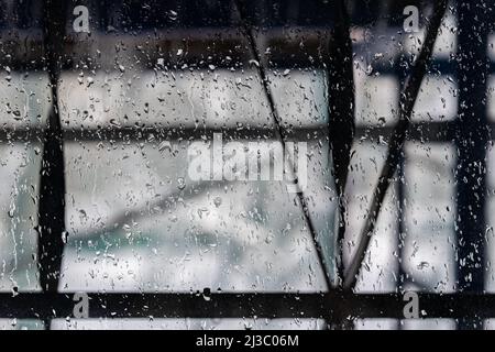 window pane covered with raindrops that are in focus Stock Photo