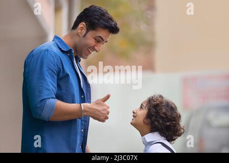 Little school boy getting praise from his father for good work Stock Photo