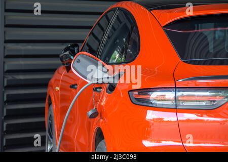 Socket plug with charging for red electric car, battery charging close up view. Electricity station Stock Photo