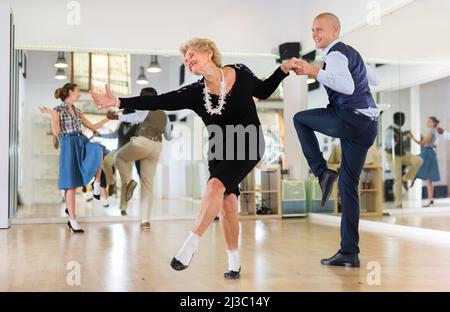 Mature woman dancing swing with young man Stock Photo