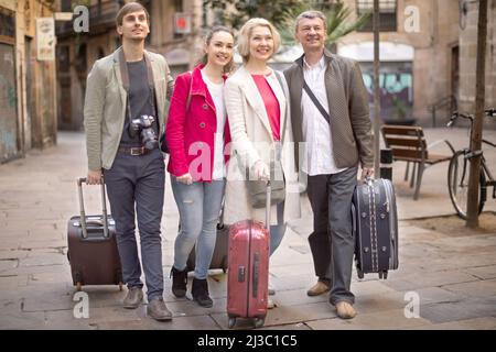 tourists with suitcases and camera walk along the historic streets of European city Stock Photo