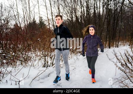 two twin brother and sister running in winter forest Stock Photo - Alamy