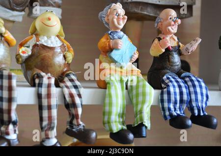 Souvenirs toys and vintage resin grandfather old man doll and retro grandmother senior woman on shelf for show in local gifts shop for thai people tra Stock Photo