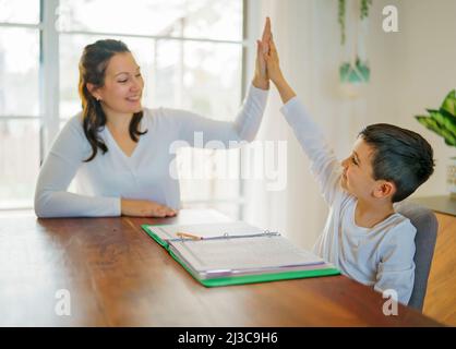 Mother and child doing homework at home Stock Photo