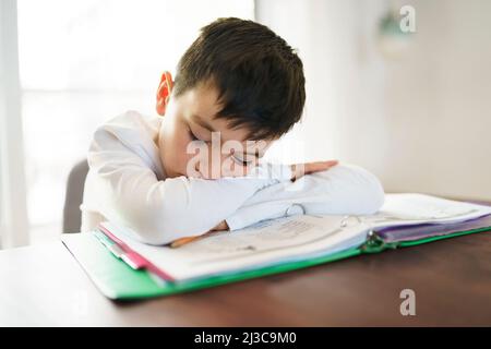 Thinking child bored and frustrated and fed up doing his homework Stock Photo