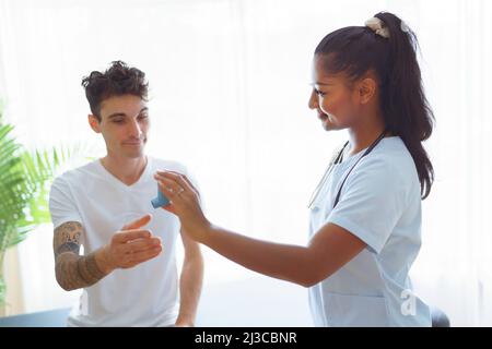 man using inhaler during asthmatic attack with doctor Stock Photo
