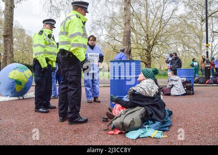 London, England, UK. 7th Apr, 2022. Police officers speak with protesters glued to a barrel. Extinction Rebellion doctors and health workers blocked the street outside HM Treasury in Westminster on World Health Day, in protest against the government's financing of fossil fuels. Several protesters glued themselves to barrels. (Credit Image: © Vuk Valcic/ZUMA Press Wire) Stock Photo