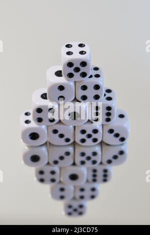 Playing dice mounted in a pyramid with reflection on a mirror Stock Photo