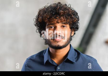 Webcam shot of middle eastern young curly guy, looking into the camera and smiling. Video screen, video chat, online call concept Stock Photo