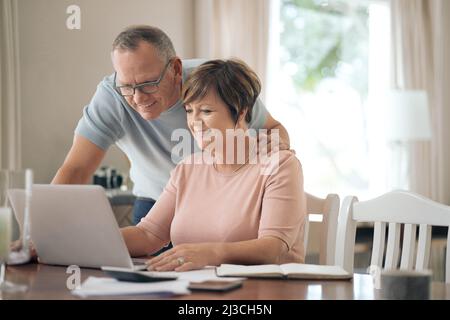 Im so proud of you honey. Shot of a mature husband and wife using a laptop together. Stock Photo