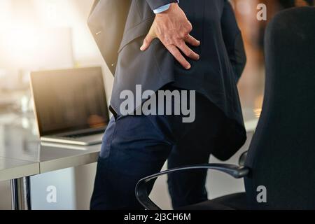 Time for a new office chair. Shot of a businessman suffering from back pain. Stock Photo