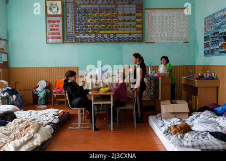 ZAKARPATTIA REGION, UKRAINE - APRIL 06, 2022 - A 13-year-old Angelina, her 8-year-old sister Anastasiia, and their mother Viktoriia from Kyiv have lunch at the school chemistry lab that has become their temporary home. A school in the town of Perechyn is home to 118 internally displaced persons who have fled Russian aggression. Among them are 21 children, Zakarpattia Region, western Ukraine Photo by Serhii Hudak/Ukrinform/ABACAPRESS.COM Stock Photo