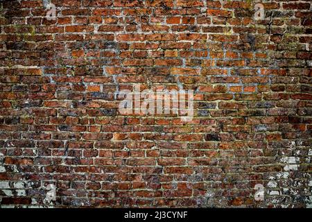 A full frame texture background of a large, worn and weathered red brick wall with copy space Stock Photo