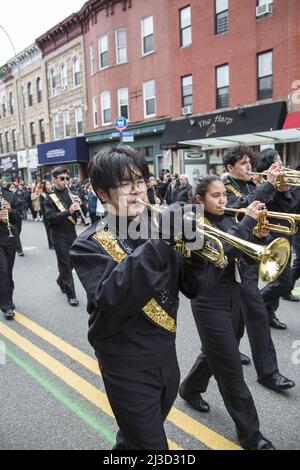 Trumpeter in a high school marching band performs at the Saint Patrick's Day Parade in the Bay Ridge neighborhood of Brooklyn, New York. Stock Photo