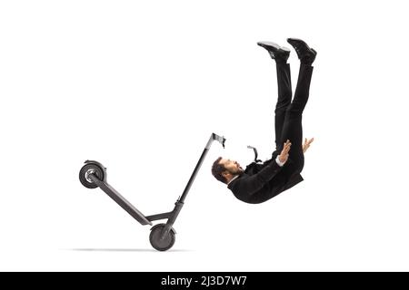 Professional man in a suit and tie falling from an electric scooter isolated on white backgroundd Stock Photo