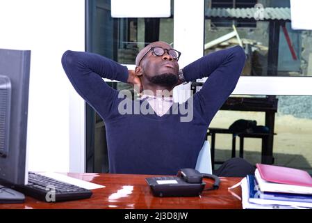 tired adult businessman stretching his body at the office. Stock Photo