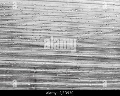 Raindrops on stretched plastic wrapping with wrinkles Stock Photo
