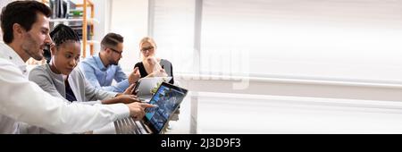 Side View Of Businesspeople Examining Graph On Computer At Workplace Stock Photo
