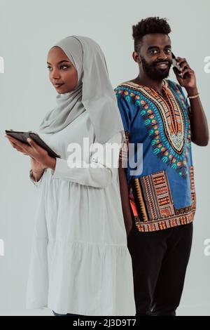 Young african business team woman wearing traditional sudan muslim hijab clothes using tablet computer isolated on white background students couple Stock Photo