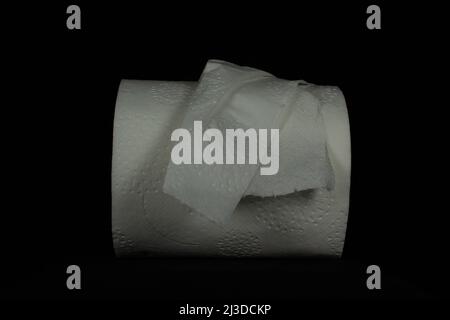 horizontal half used roll of toilet paper isolated on a black background