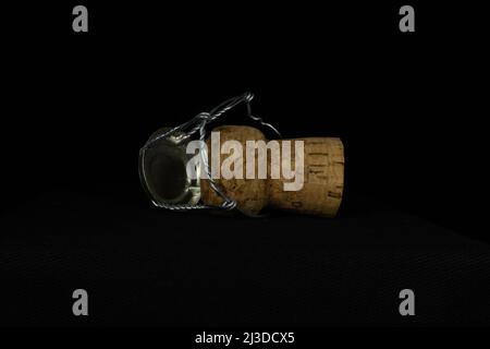 sparkling wine cork and wire cage isolated on a black background Stock Photo