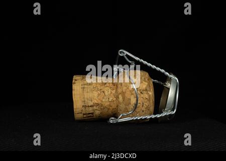 sparkling wine cork inside a wire cage isolated on a black background Stock Photo