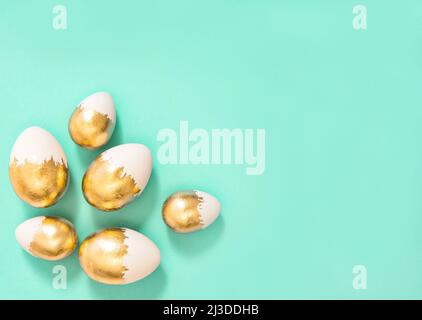 Easter decoration. Golden Easter eggs on turquoise background Stock Photo