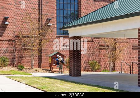 CONCORD, NC, USA-3 APRIL 2022: Man using a 'Blessing Box' on the grounds of the Rotary Club of Concord park. Stock Photo