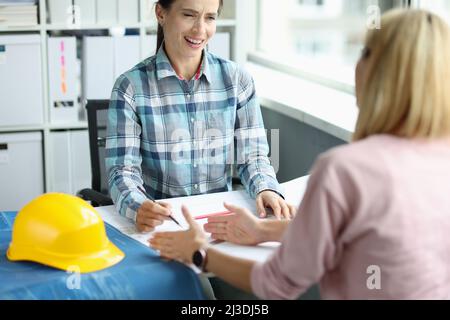 Woman architect communicates with client on construction planning Stock Photo