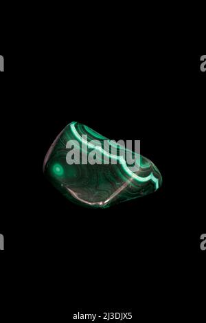Polished Malachite mineral, decorative stone on black background. Stock Photo