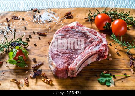 Raw steak on the bone on a wooden surface Stock Photo